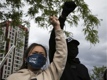 Protesters raise their fist in solidarity during an anti-racist and anti-police brutality demonstration on Sunday, May 31, 2020, in Montreal.