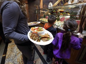 In this April 18, 2014 photo, passengers get lunch at the Carvery, of the Grand Buffet, aboard the Carnival Splendor cruise ship, in New York.