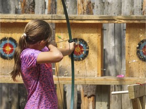 A girl takes aim at a target on the archery range at a St-Lazare day camp in 2015.