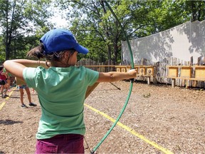 A girl takes aim at a target on the archery range at St-Lazare's day camp at the Centre de Plein Air et Forestiers de St-Lazare, west of Montreal Tuesday July 14, 2015.