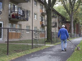 A walks his dog past the Jeanne Mance social housing complex between Ontario St. and de Maisonneuve Blvd. in 2015. Earlier investments in social housing "have made our cities and towns more resilient in the face of the economic and social crisis we are currently experiencing," Mayor Valérie Plante writes.