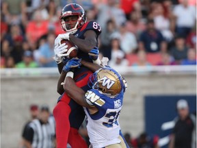 Alouettes receiver Eugene Lewis makes a leaping catch above Winnipeg Blue Bombers' Marcus Rios in Montreal on Sept. 21, 2019.
