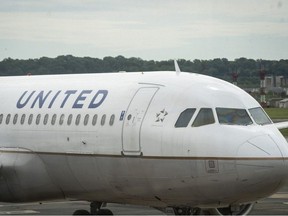 A United Airlines plane sits at a gate Ronald Reagan Washington National Airport, May 5, 2020 in Arlington, Virginia.