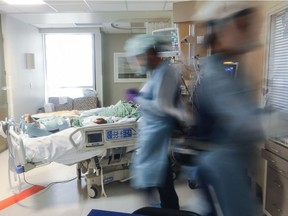 Clinicians are blurred as they care for a COVID-19 patient in the Intensive Care Unit (ICU) at Sharp Memorial Hospital amid the coronavirus pandemic on May 6, 2020, in San Diego.