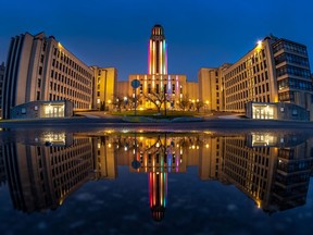 The University of Montreal, reflected in a puddle, lit their centre tower in rainbow lights April 29, 2020.