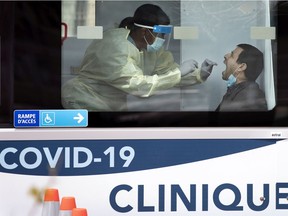 A health-care worker administers a test swab at a mobile COVID-19 testing site in Montreal on May 9, 2020.