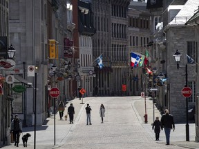 A woman has her picture taken on a near empty Saint-Paul Street in Old Montreal, on Tuesday, May 12, 2020. (Allen McInnis / MONTREAL GAZETTE) ORG XMIT: 64340