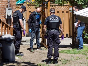 Police investigate the backyard at 1960 40th Avenue in Pointe aux Trembles for clues.