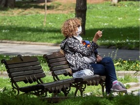 A woman with a protective mask smokes a cigarette in a park in Skopje on April 23, 2020. "Please, in the name of all that is holy, do not start smoking," physician Christopher Labos writes.