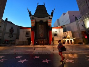 A woman walks past the closed courtyard of Hollywood's iconic TCL Chinese Theater, famed for the hand and foot prints of movie stars. Montreal film industry players are pushing to reopen cinemas mid-June or July.