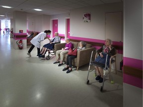 A physiotherapist speaks with residents of a seniors' care home in France on May, 6, 2020. "It’s surprising we have so few alternatives to institutional long-term care," Janet Torge writes.