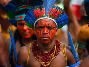 In this file photo taken on March 11, 2020, Brazilian indigenous leaders and tribe members hold a protest demanding the demarcation of indigenous lands, in Brasilia.