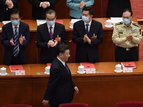 Chinese President Xi Jinping is applauded by, from left, State Councilor Xiao Jie, Foreign Minister Wang YiState Councilor Wang Yong, and Defence Minister Wei Fenghe, as he arrives for the closing session of the National People's Congress in Beijing.