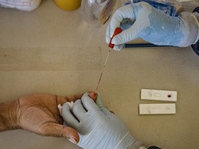 A health worker conducts a COVID-19 rapid antibody test.