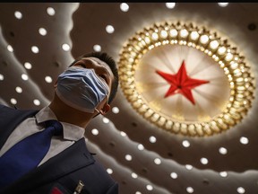 A Chinese security officer wears a protective mask at the end of the closing session of the National People's Congress at the Great Hall of the People on May 28, 2020 in Beijing, China.