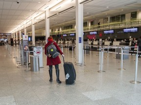 A passenger makes her way to the check in for a flight at Montreal’s Trudeau International Airport on March 30, 2020.