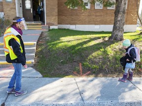 Teacher Janick Mille welcomes a student at École Marie Rose in Saint Sauveur on Monday morning.