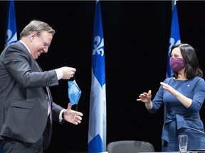 Premier François Legault is told to slip on his protective mask by Mayor Valérie Plante after a news conference in Montreal on Thursday, May 14, 2020.
