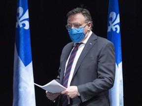 Quebec Premier Francois Legault arrives at a news conference wearing a protective mask in Montreal on May 14, 2020.