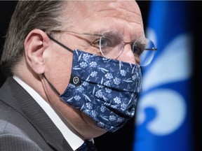 Quebec Premier François Legault leaves a COVID-19 news conference in Montreal on Friday, May 15, 2020, while wearing a face mask.
