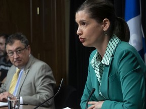 Quebec Deputy Premier and Public Security Minister Genevieve Guilbault responds to reporters during a news conference on the COVID-19 pandemic, Wednesday, May 20, 2020 at the legislature in Quebec City. Horacio Arruda, Quebec director of National Public Health, left, looks on.