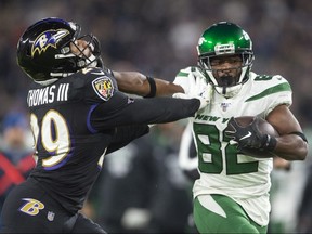 New York Jets wide receiver Jamison Crowder (82) stiff arms Baltimore Ravens free safety Earl Thomas (29) at M and T Bank Stadium.