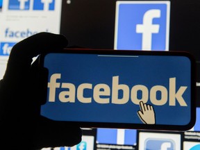 The Facebook logo is displayed on a mobile phone in this picture illustration taken Dec. 2, 2019. Bob Cox, publisher of the Winnipeg Free Press and one of the signatories of the letter, says newspaper ad revenues in Canada have fallen by at least 50 per cent, which has made the newspaper industry unviable.