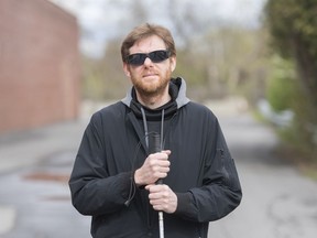 Nick D'Ambrosio poses outside his place of work in Montreal, Saturday, May 16, 2020. Maintaining a two-metre distance from members of the public is a challenge for the 49-year-old, who has lost most of his eyesight and now travels with a white cane.