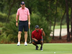 Tiger Woods and former NFL player Peyton Manning read a putt on the sixth green during The Match: Champions for Charity golf round at the Medalist Golf Club on Sunday, May 24, 2020.