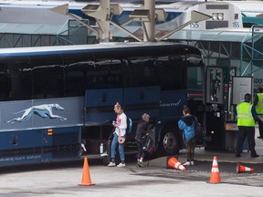 Passengers place their luggage on a Greyhound bus before departing from Vancouver, on Monday July 9, 2018.