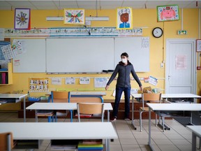 A teacher in France walks into a deserted classroom at a private school for children of frontline workers.