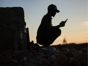 Ali, a migrant from Mali, looks at his phone during the coronavirus outbreak in southern Spain.