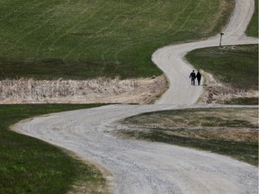 Two people walk along a gravel road amid the coronavirus outbreak in Sabattus, Maine, on April 25, 2020.