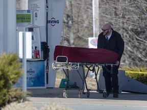 A worker with the medical examiner's office removes the body of Gabriel Wortman from a gas bar in Enfield, N.S. on Sunday, April 19, 2020. A newly released document confirms that in May 2011 police were told that Wortman -- the Nova Scotia man who would later slaughter 22 people in a shooting rampage -- wanted to "kill a cop" and was feeling mentally unstable.
