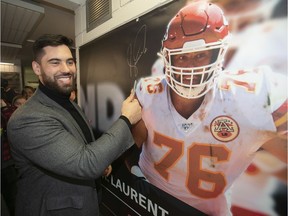 Laurent Duvernay-Tardif is all smiles after signing banner of himself that was unveiled at the McGill sports centre on Feb. 12, 2020 after he helped the Kansas City Chiefs win the Super Bowl.