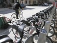 A cyclist goes past  a Bixi station.