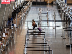 A lone passenger heads to the departure gates at Montreal's Pierre Elliott Trudeau International Airport on May 7, 2020.