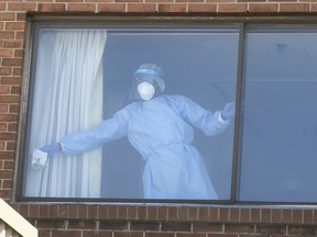A worker washes down and disinfects a room at the CHSLD Vigi Mont-Royal on May 14, 2020, during the COVID-19 pandemic.