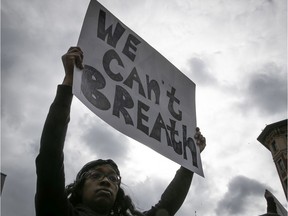 A protester holds up sign during an anti-racist and anti-police brutality demonstration on Sunday May 31, 2020.