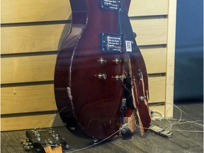 A smashed guitar leans against a wall in Steve’s Music Store on Saint-Catherine St. in Montreal on Monday, the day after store was looted.