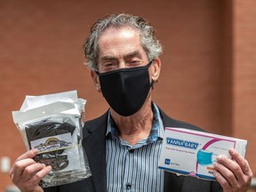 Côte-St-Luc Mayor Mitchell Brownstein holds up masks in June 2020.