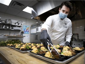 Executive chef Joris Larigaldie plates meals prepared by W Hotel kitchen staff for the homeless.