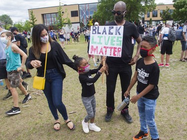 Fabrice Prosper and Namita Khatri, with their children Anayaa (left) and Shaan attend an event called Montreal Kneels for Change at Loyola park in Montreal Sunday, June 7, 2020.