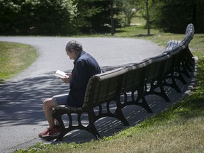 A man practices good social distancing while reading a book at Jarry park on Friday June 12, 2020. (Pierre Obendrauf / MONTREAL GAZETTE)