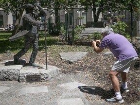 Spiros Haliotis takes a picture of the James McGill statue on the front lawn of McGill university on Monday June 15, 2020.