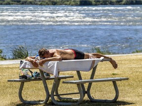 A sun bather lies on a picnic table near the Lachine rapids in LaSalle June 17, 2020.
