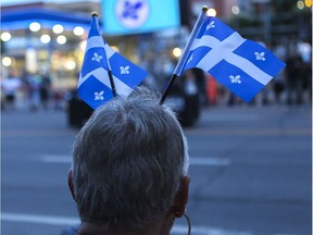 A woman watches the Fête nationale parade on St-Denis St. In Montreal on June 24, 2019.