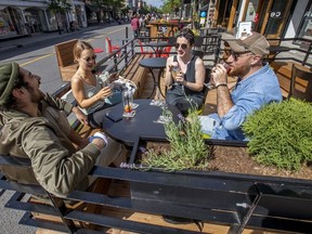 Roommates Clément Buyse, left, Elena Hasse, Caroline Dujardin and Oswald De Cruz enjoy drinks on the terrasse of Les Enfants du Rock Montréal on Mont-Royal Ave. on Thursday June 25, 2020.