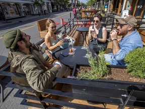 Roommates, from left, Clément Buyse, Elena Hasse, Caroline Dujardin and Oswald De Cruz enjoy drinks on the terrasse of Les Enfants du Rock in Montreal's Plateau Mont-Royal district on Thursday, June 25, 2020.