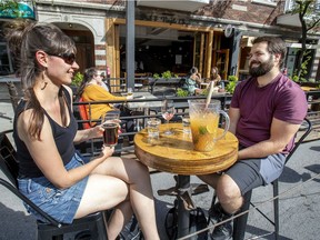 A couple of customers at Pub West Shefford in Montreal’s Plateau Mont-Royal district enjoy drinks on the terrace on June 25 after the provincial government gave the go-ahead for bars to reopen.